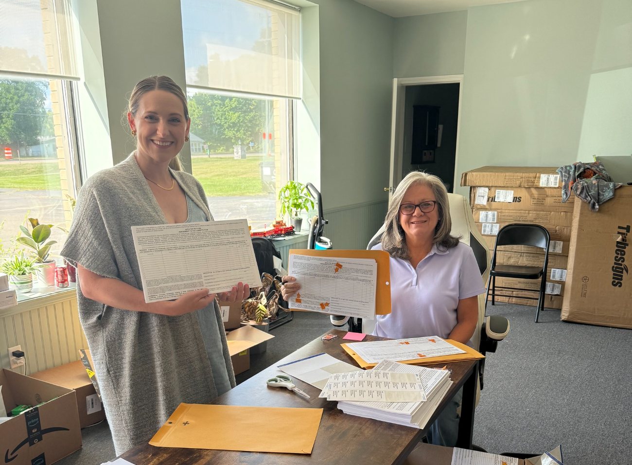 Victory Field Operations staff reviewing and processing completed petition sheets at the operations office.